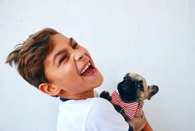 young boy holding a pug puppy