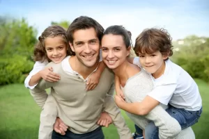family of four smiling for pictures - family dentistry services