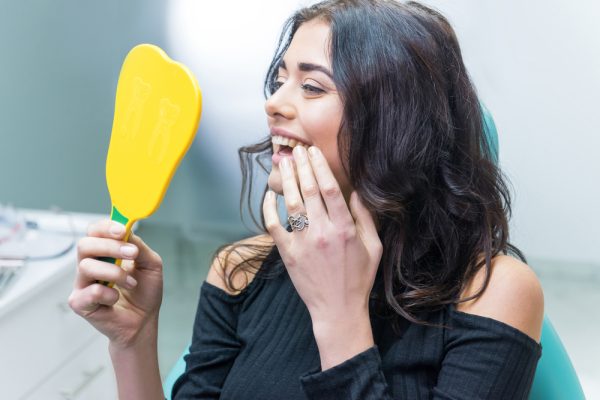 woman looking at her smile at the dentist